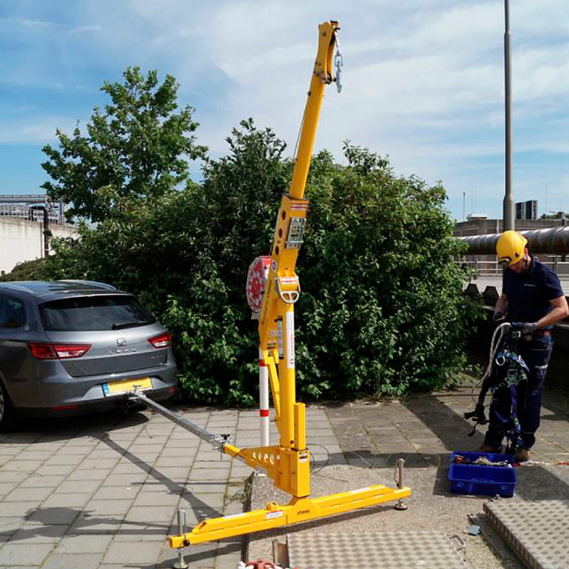 Coche aparcado en acera con brazo de rescate anclado a su bola de remolque, con el fin de acceder y poder rescatar una persona del pozo contiguo.