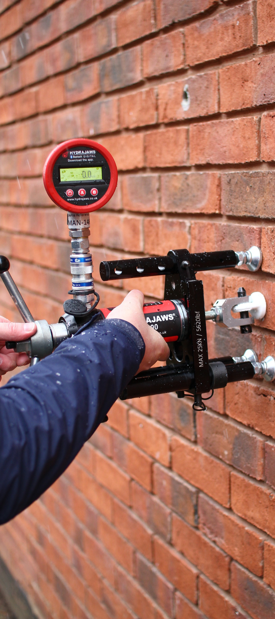 Colocación del tester para ensayar la resistencia de un anclaje en pared de ladrillo.