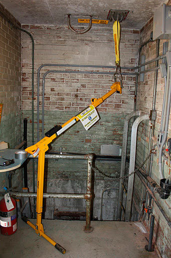 Brazo pescante suspendido del techo, con el cabezal colgando sobre el pozo o depósito, para poder rescatar una persona.