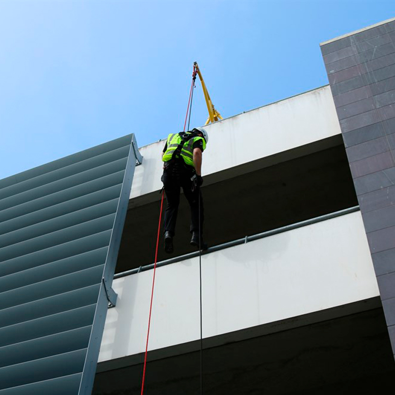 Persona en suspensión con 2 cuerdas ancladas al brazo de un carro contrapesado en cubierta.